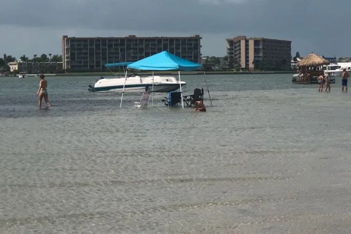 a group of people standing on top of a sandy beach