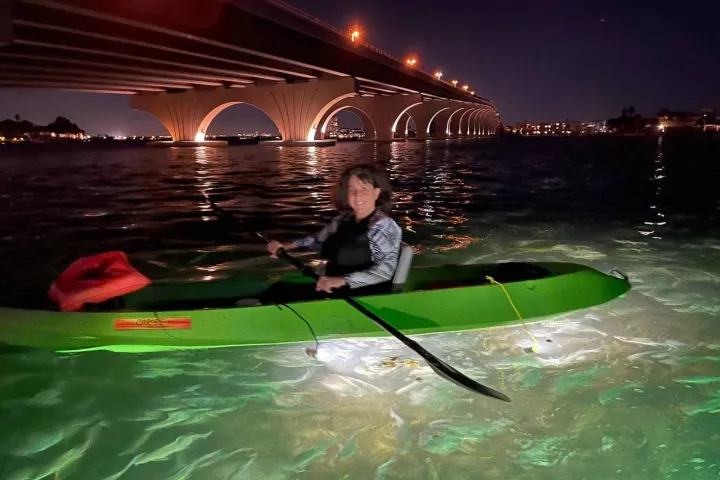 a man standing next to a body of water