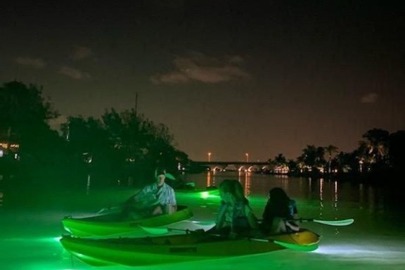 a green boat on a body of water