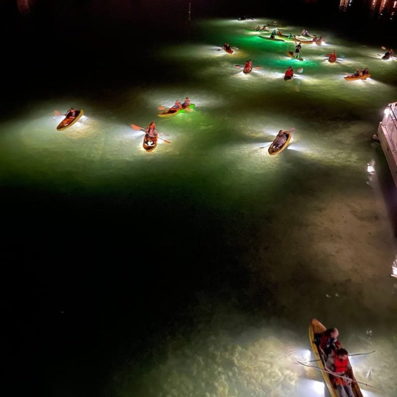 a group of people flying kites on a boat in the water
