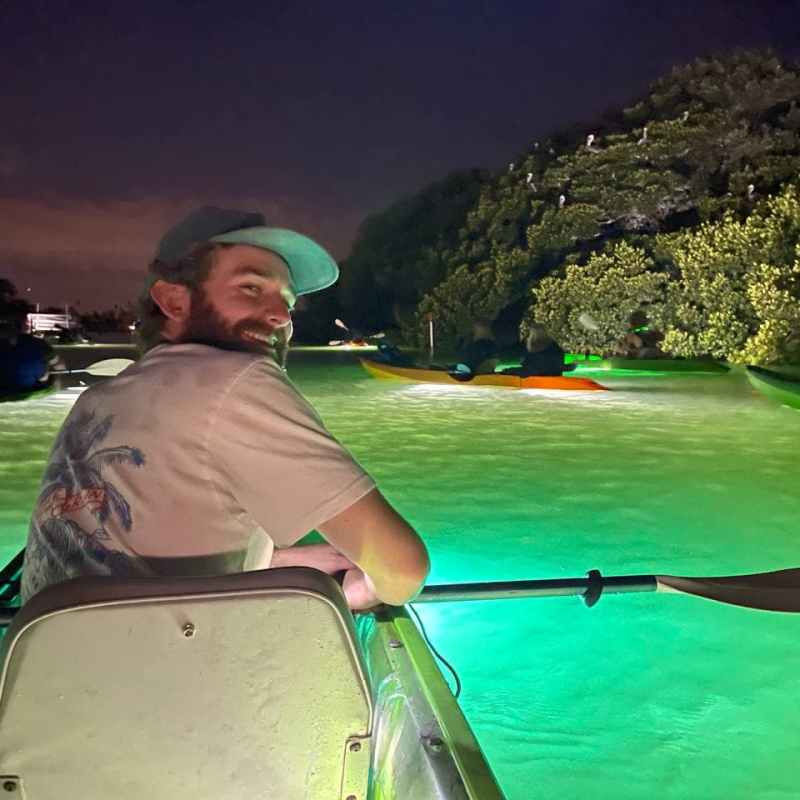 a man in a green boat on a body of water